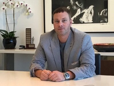 Erik Mendelson, CEO of Answerman Management, seated at desk in blazer