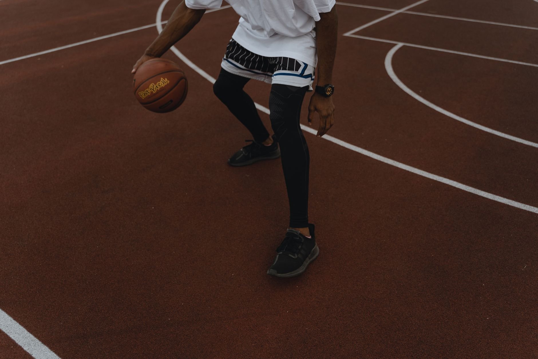 Dynamic shot of a basketball player dribbling on an outdoor court