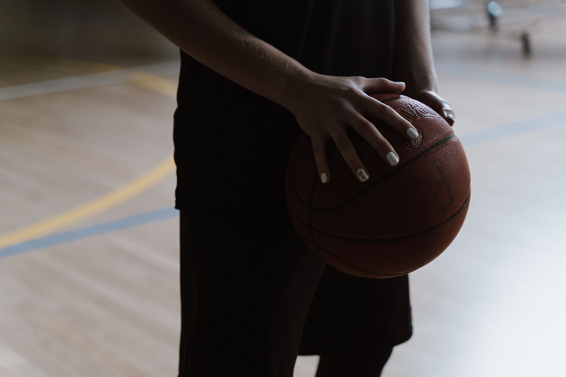 Basketball player holding a ball indoors, focused before game